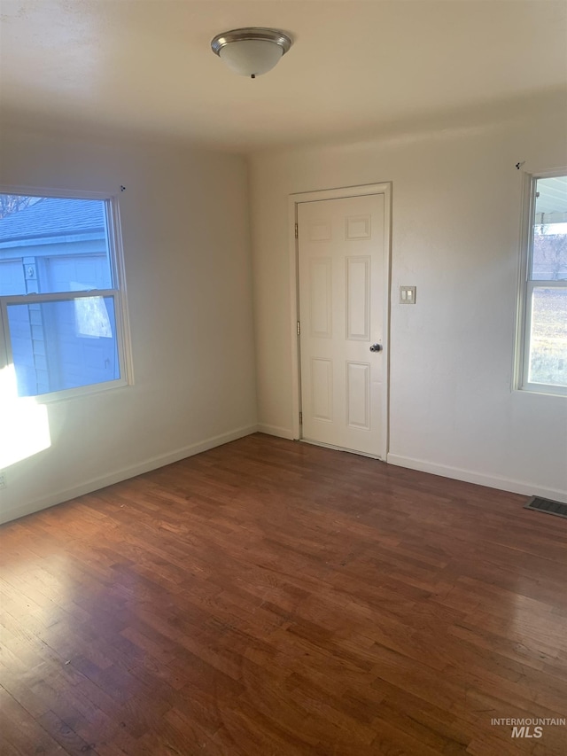 spare room with dark hardwood / wood-style floors