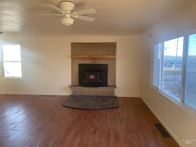 unfurnished living room featuring dark hardwood / wood-style flooring, ceiling fan, and a healthy amount of sunlight