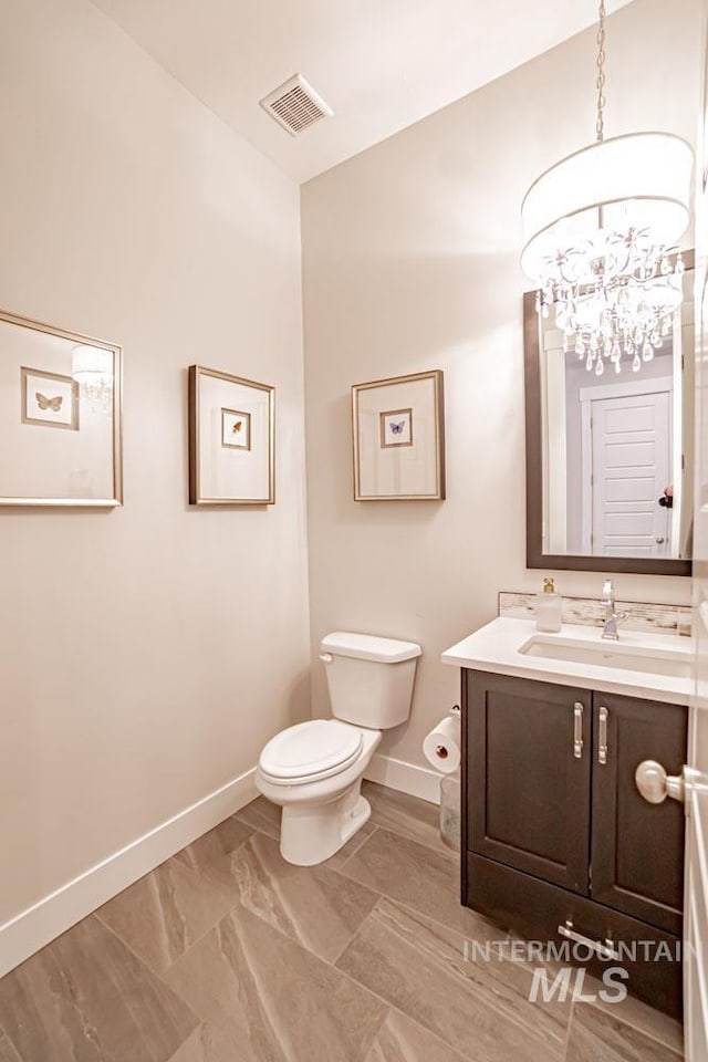 5946 E Barber Dr, Boise, ID 83716 - bathroom with vanity, baseboards, a chandelier, toilet, and visible vents
