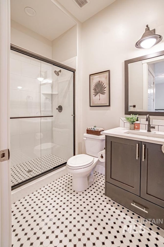 5946 E Barber Dr, Boise, ID 83716 - bathroom featuring a shower stall, vanity, visible vents, toilet, and tile patterned floors