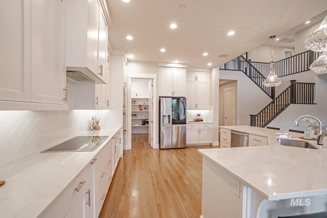 5946 E Barber Dr, Boise, ID 83716 - kitchen with light wood finished floors, a sink, white cabinets, and stainless steel appliances