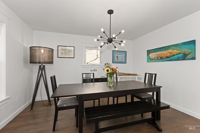 dining space with baseboards, an inviting chandelier, and wood finished floors
