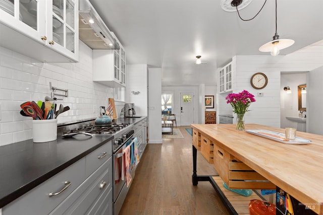 kitchen with white cabinets, dark countertops, stainless steel range, premium range hood, and decorative backsplash