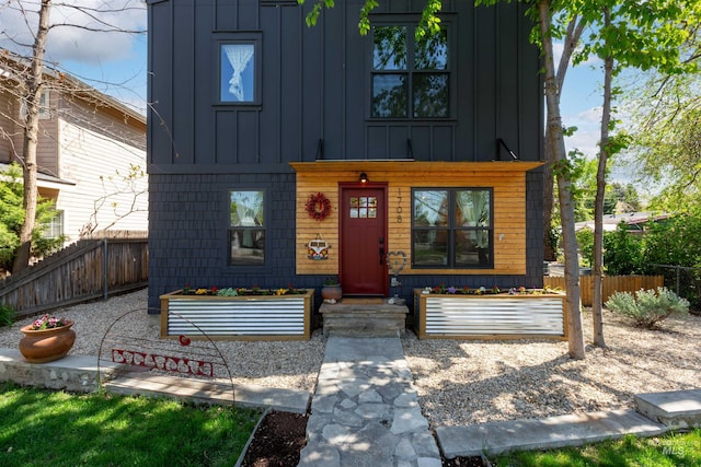view of front facade with fence and board and batten siding