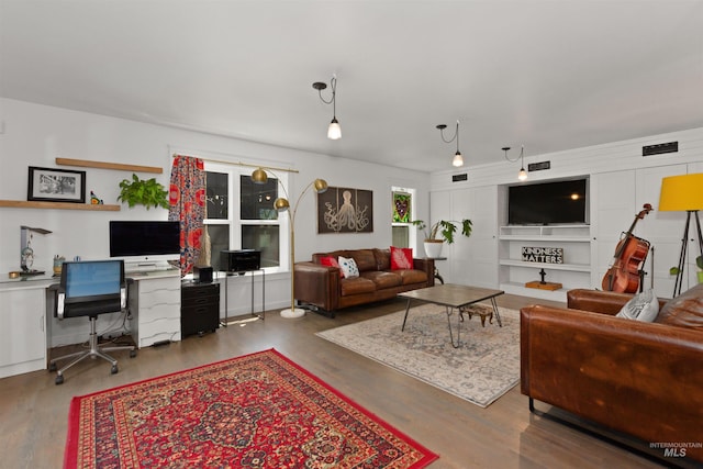 living area featuring visible vents and wood finished floors