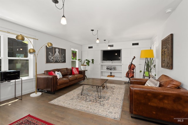 living area featuring wood finished floors and visible vents