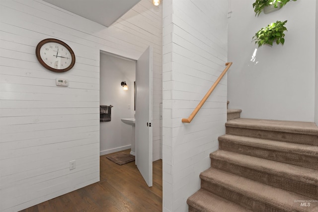 stairs with wood walls and wood finished floors