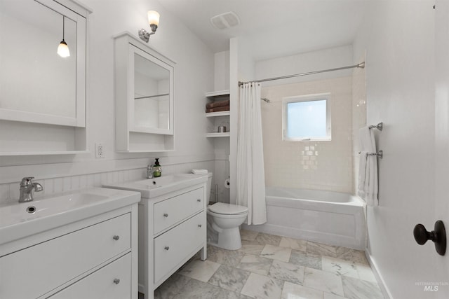 full bath featuring a sink, two vanities, toilet, and shower / tub combo