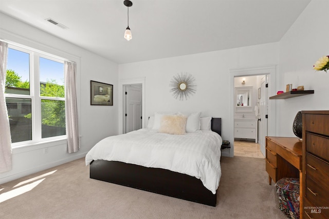 bedroom featuring connected bathroom, visible vents, and carpet