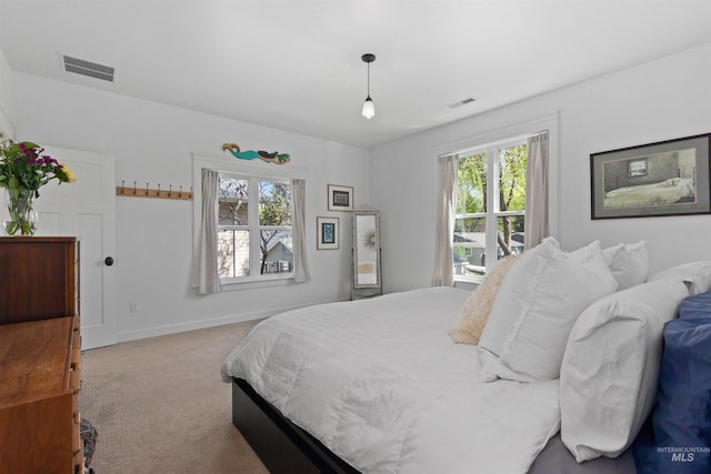 bedroom featuring carpet floors, visible vents, and multiple windows