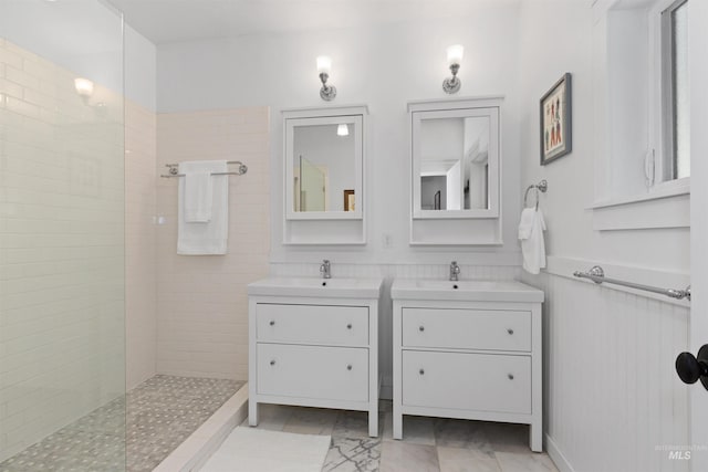 bathroom with a sink, walk in shower, and two vanities