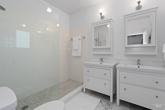 full bathroom with a sink, a walk in shower, toilet, and two vanities