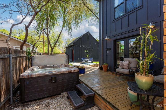 wooden terrace with a hot tub and fence