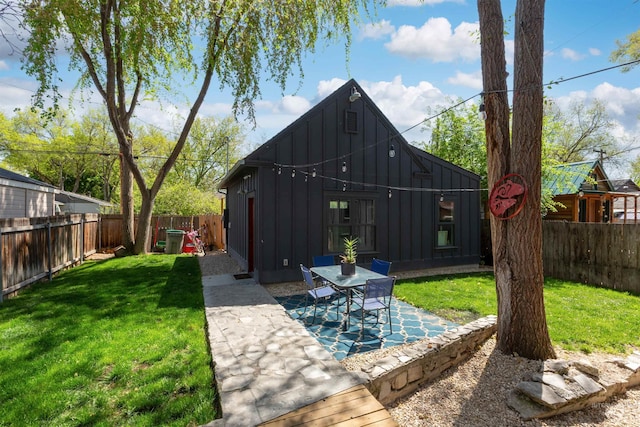exterior space featuring a fenced backyard, a patio, board and batten siding, and a yard