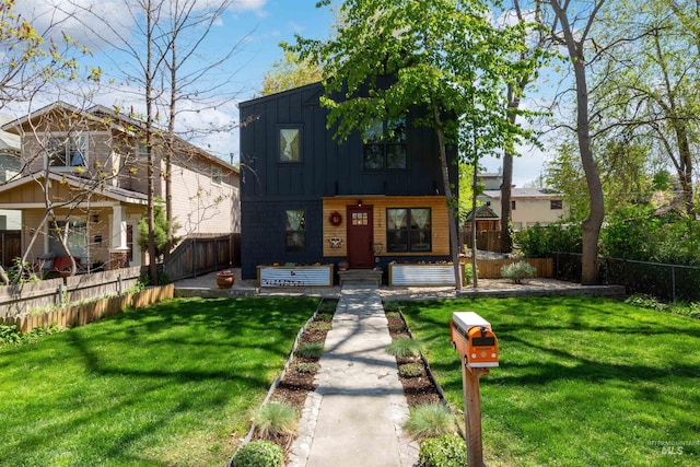 view of front of property featuring a porch, board and batten siding, fence private yard, and a front yard
