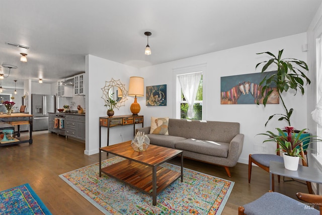 living area featuring baseboards and dark wood-style floors