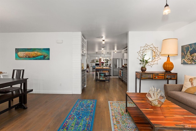 living area with baseboards and dark wood-style flooring