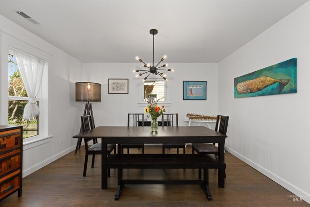 dining area featuring baseboards, a notable chandelier, visible vents, and dark wood finished floors