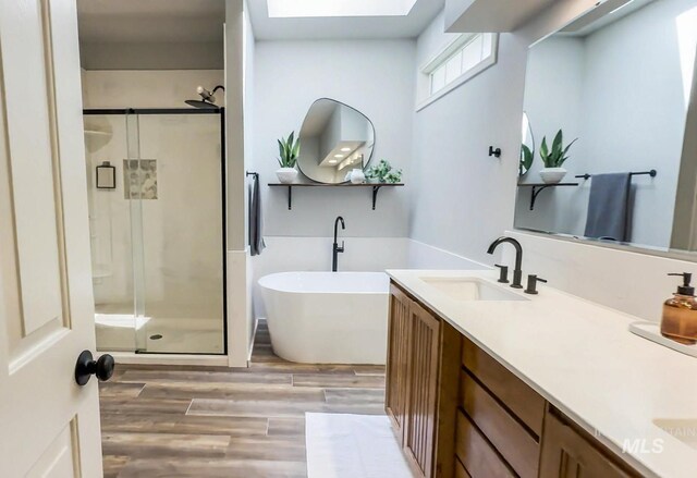 104 E Stonewater, Eagle, ID 83616 - bathroom with a stall shower, wood finished floors, double vanity, and a soaking tub