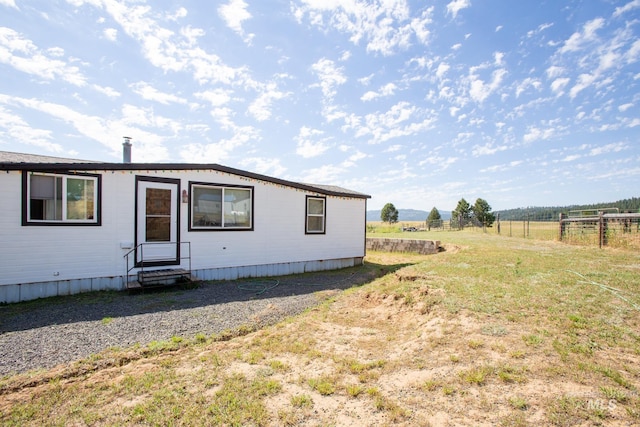 manufactured / mobile home with a rural view and a front lawn