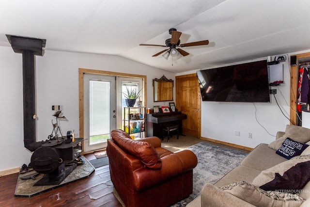 living room with a wood stove, dark wood-type flooring, lofted ceiling, and ceiling fan