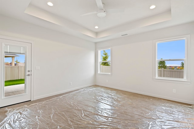 spare room with a tray ceiling and ceiling fan