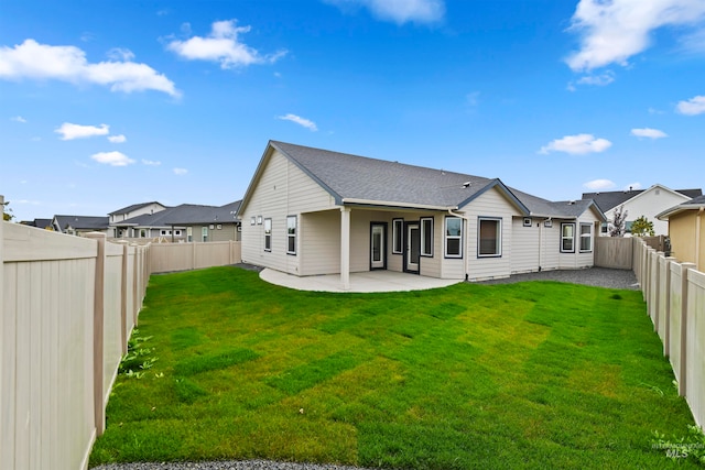 back of house with a patio area and a lawn