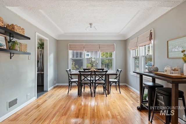 176 Taylor St, Twin Falls, ID 83301 - dining space featuring a textured ceiling, light wood-style floors, and baseboards