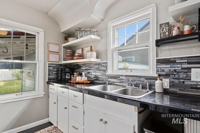 kitchen featuring white cabinetry, sink, and tasteful backsplash