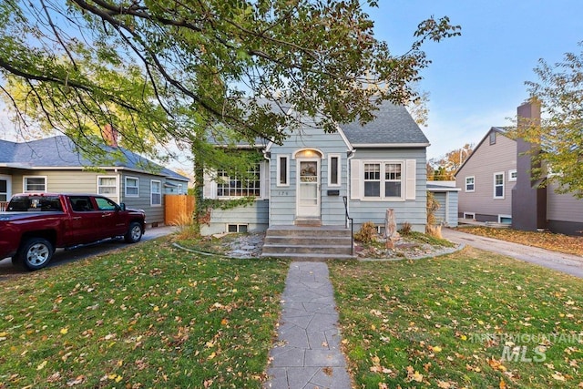 bungalow-style home with a front yard