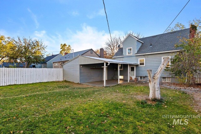 back of property with a patio and a yard