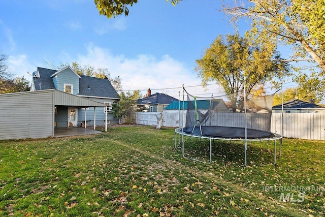 view of yard featuring a trampoline and a patio