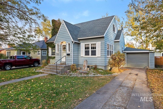 bungalow-style home featuring an outbuilding, a front yard, and a garage