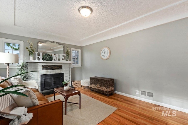176 Taylor St, Twin Falls, ID 83301 - living room with baseboards, wood finished floors, a brick fireplace, and a textured ceiling
