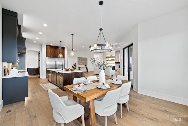 dining space with light wood-type flooring and an inviting chandelier