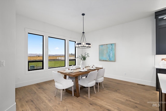 dining area featuring wood-type flooring and an inviting chandelier