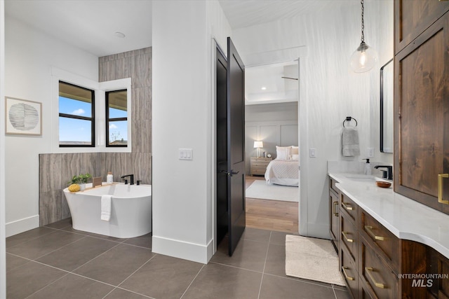 bathroom featuring tile patterned floors, vanity, and a tub to relax in