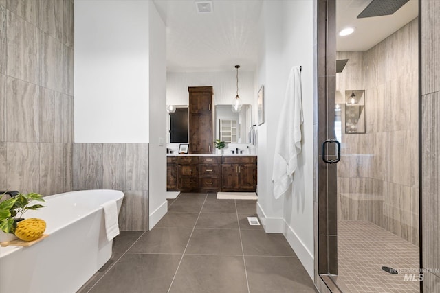 bathroom featuring tile patterned floors, vanity, tile walls, and plus walk in shower