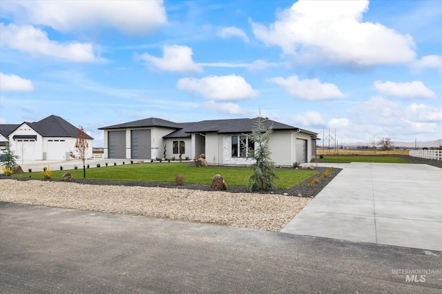 view of front of house featuring a garage and a front lawn