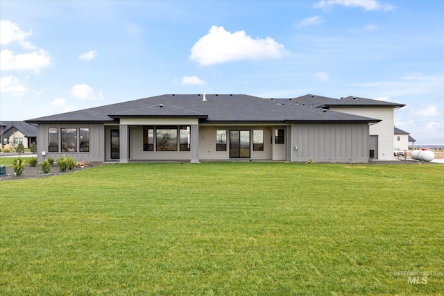 rear view of property with a lawn