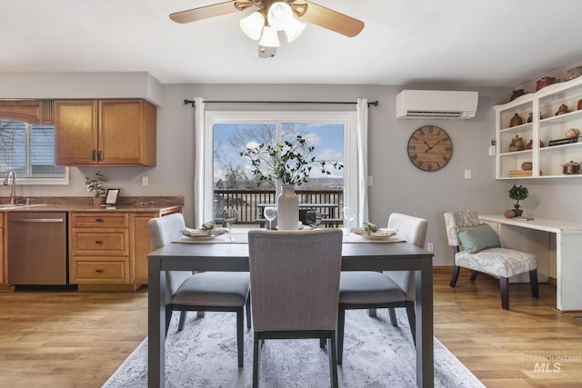 dining room with sink, light hardwood / wood-style flooring, an AC wall unit, and ceiling fan