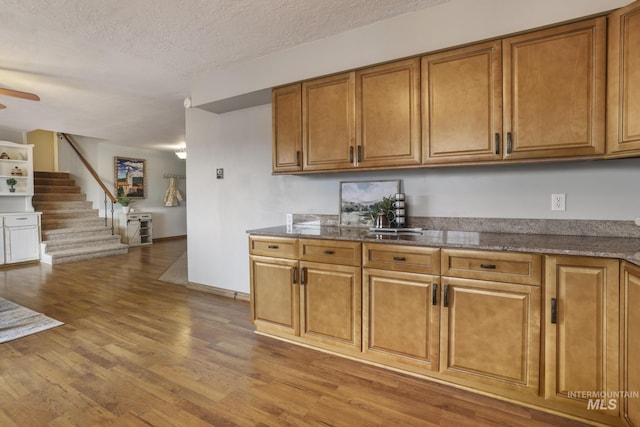 kitchen with ceiling fan, light hardwood / wood-style flooring, and a textured ceiling