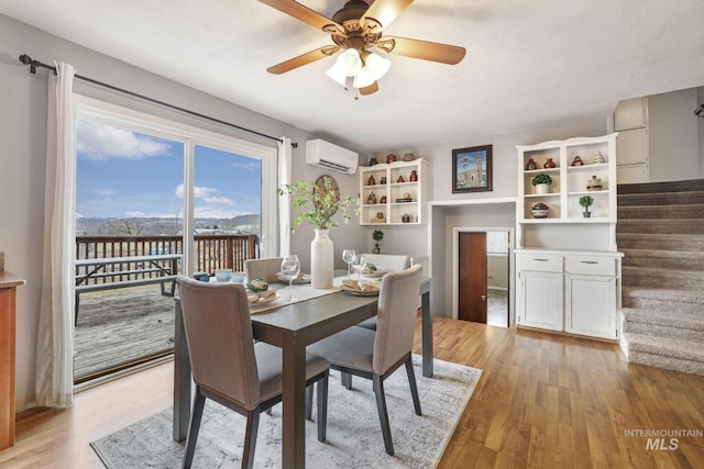 dining room with ceiling fan, light hardwood / wood-style floors, and an AC wall unit