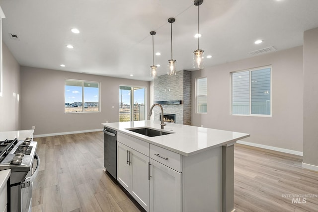 kitchen featuring open floor plan, appliances with stainless steel finishes, visible vents, and a sink