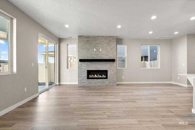 unfurnished living room with light wood-style flooring, recessed lighting, and baseboards