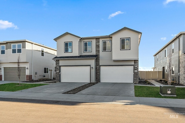 view of front of property featuring stone siding, driveway, and an attached garage