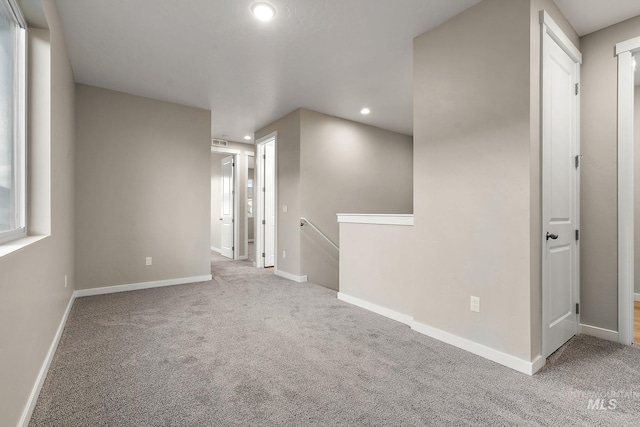 empty room featuring carpet flooring, recessed lighting, and baseboards