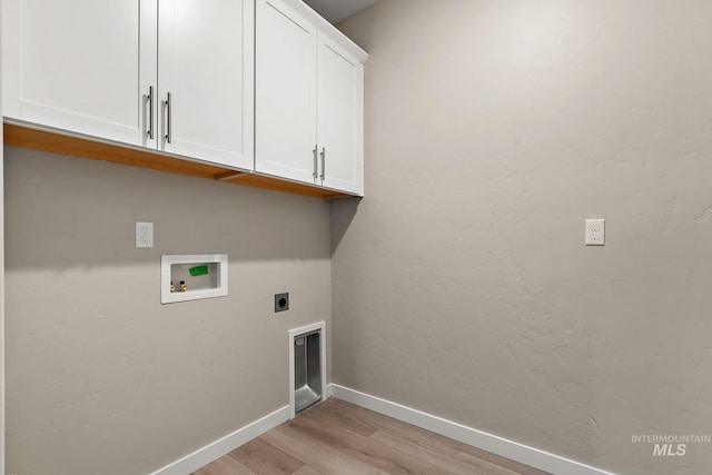 clothes washing area featuring baseboards, light wood finished floors, cabinet space, electric dryer hookup, and washer hookup