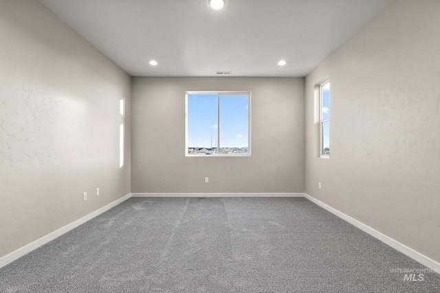 spare room with recessed lighting, visible vents, baseboards, and carpet