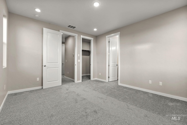 unfurnished bedroom with recessed lighting, carpet, visible vents, and baseboards